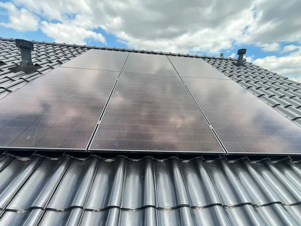 Close-up van zwarte zonnepanelen op antraciet dakpannen