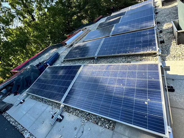 Rijen blauwe zonnepanelen op een aluminium onderconstructie op een plat grinddak